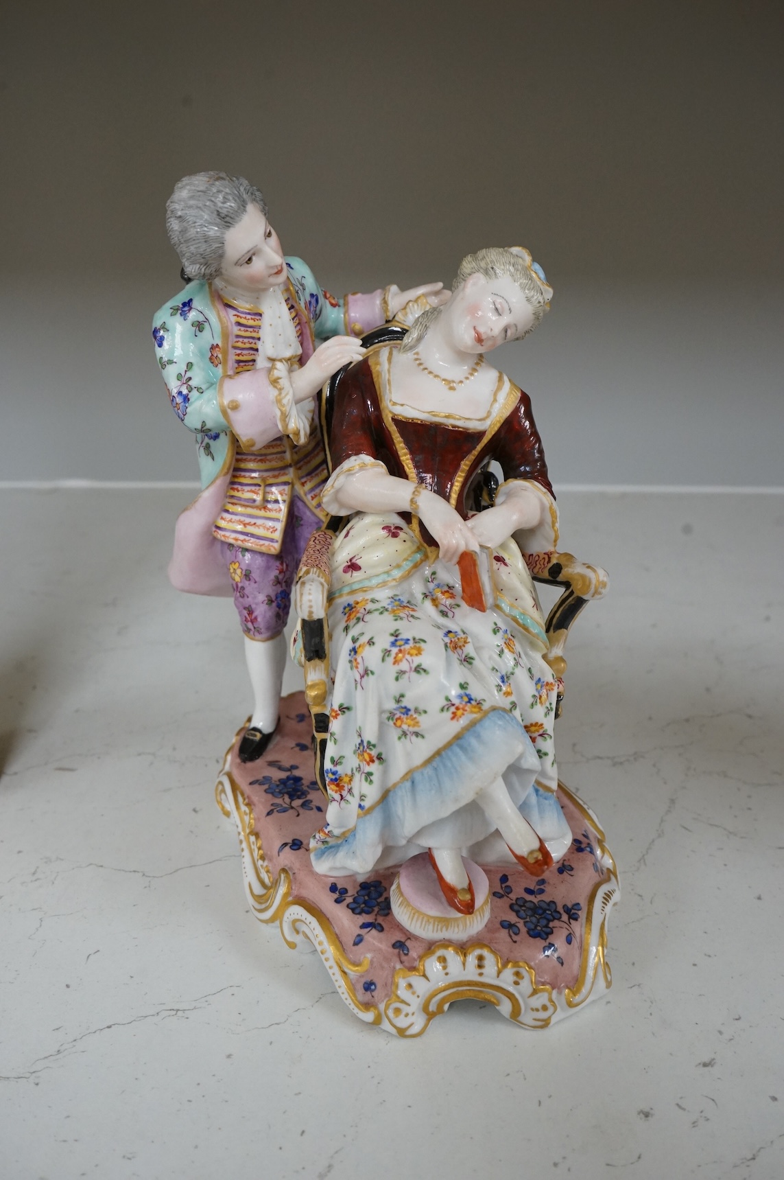 A German porcelain group of a seated sleeping beauty, 21cm high